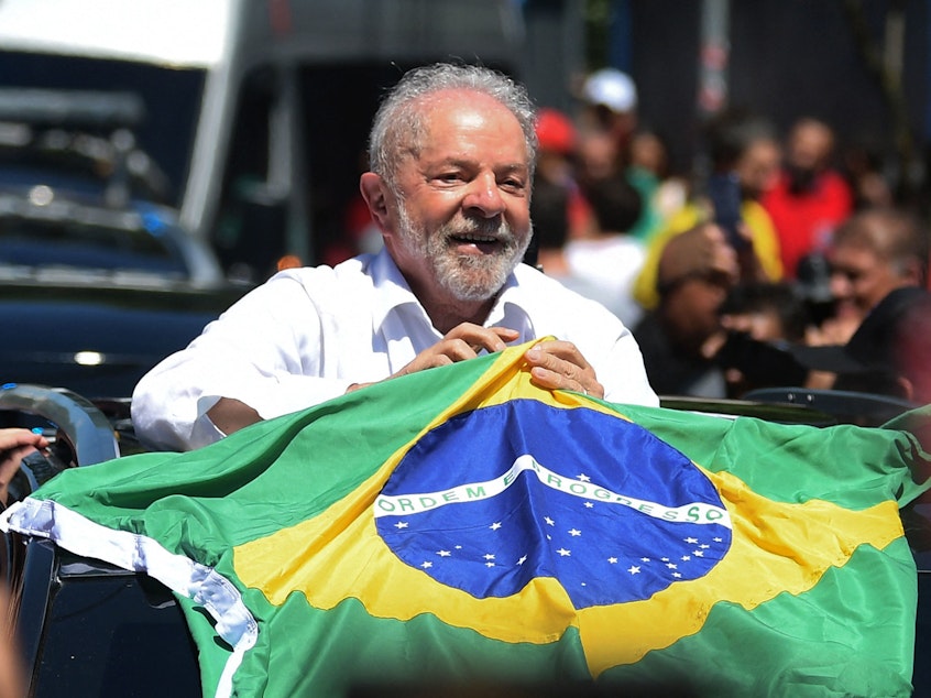 caption: Luiz Inacio Lula da Silva holds a Brazilian flag while leaving a polling station in Sao Paolo during Sunday's presidential runoff election.
