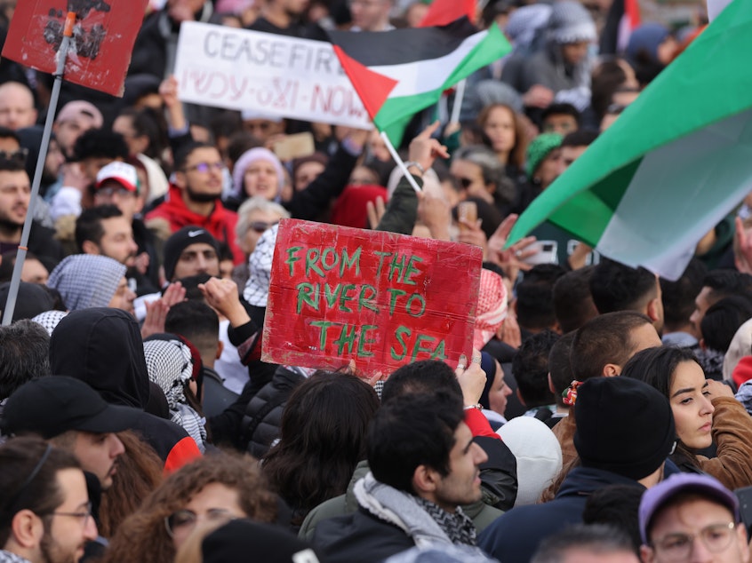 caption: A demonstrator holds a sign reading "From the river to the sea" at a Freedom for Palestine protest in Berlin on Nov. 4.