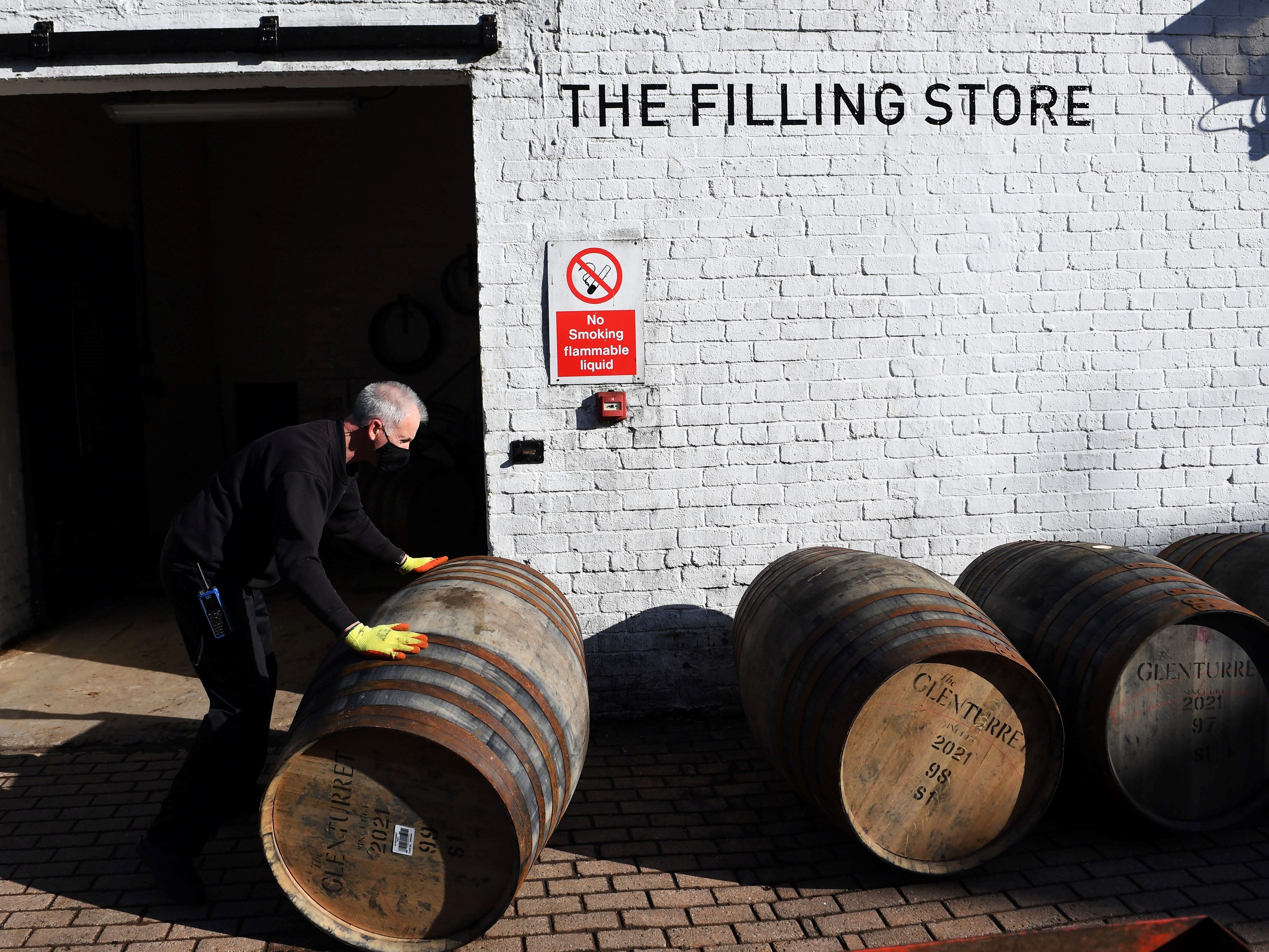 caption: Scotch whisky producers are welcoming news of a breakthrough on tariffs, which came as the industry adjusted to both Brexit and then the COVID-19 pandemic. Here, an employee rolls a whisky barrel at the Glenturret Distillery in Crieff, central Scotland, last week.