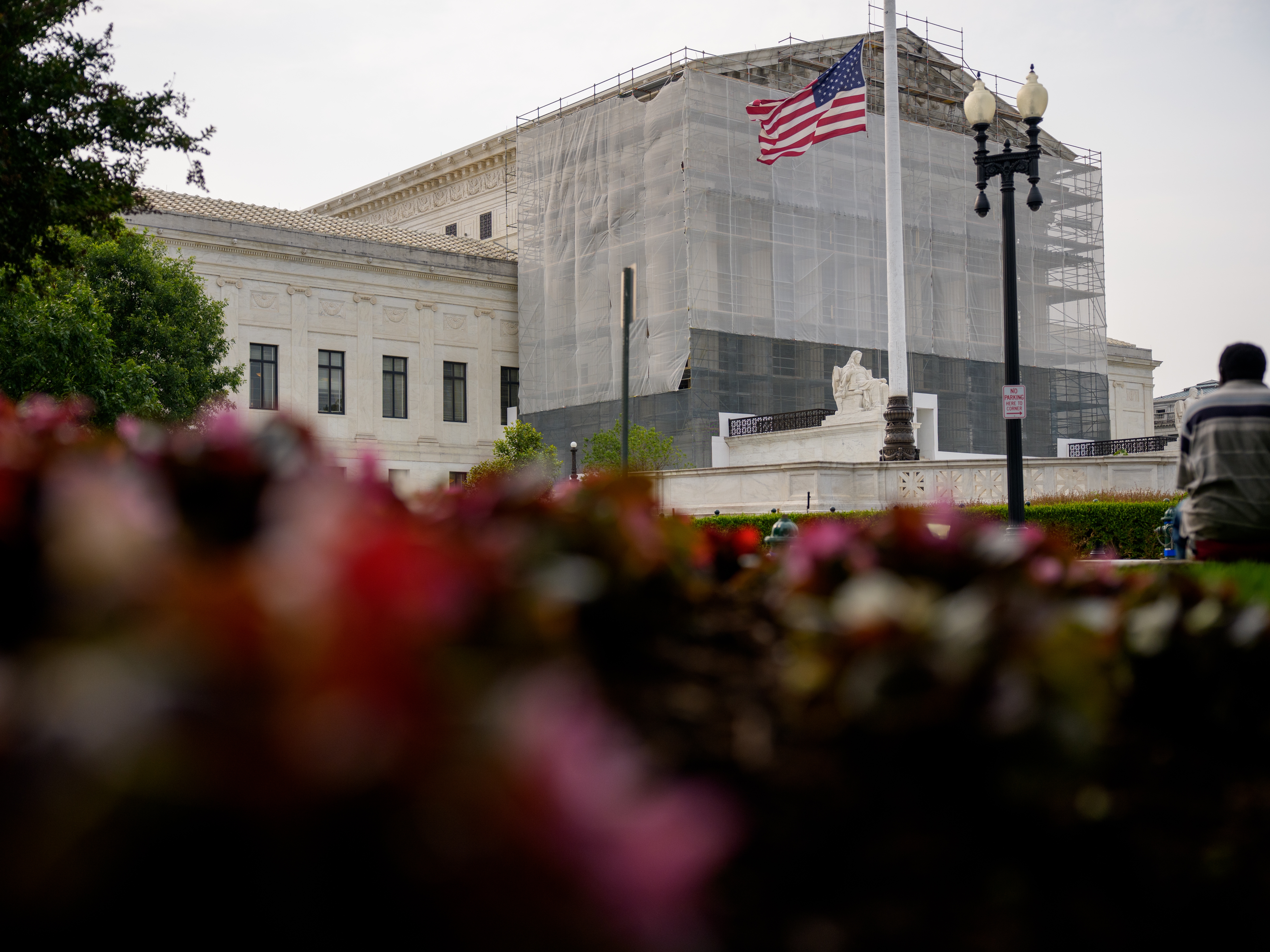 caption: A person rests in front of the U.S. Supreme Court on June 5 in Washington, D.C.