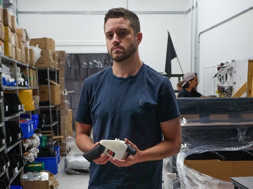 caption: Cody Wilson, owner of Defense Distributed, holds a 3D printed gun, called the "Liberator," in his factory in Austin, Texas, in August. The 30-year-old has been accused of sexually assaulting a minor.