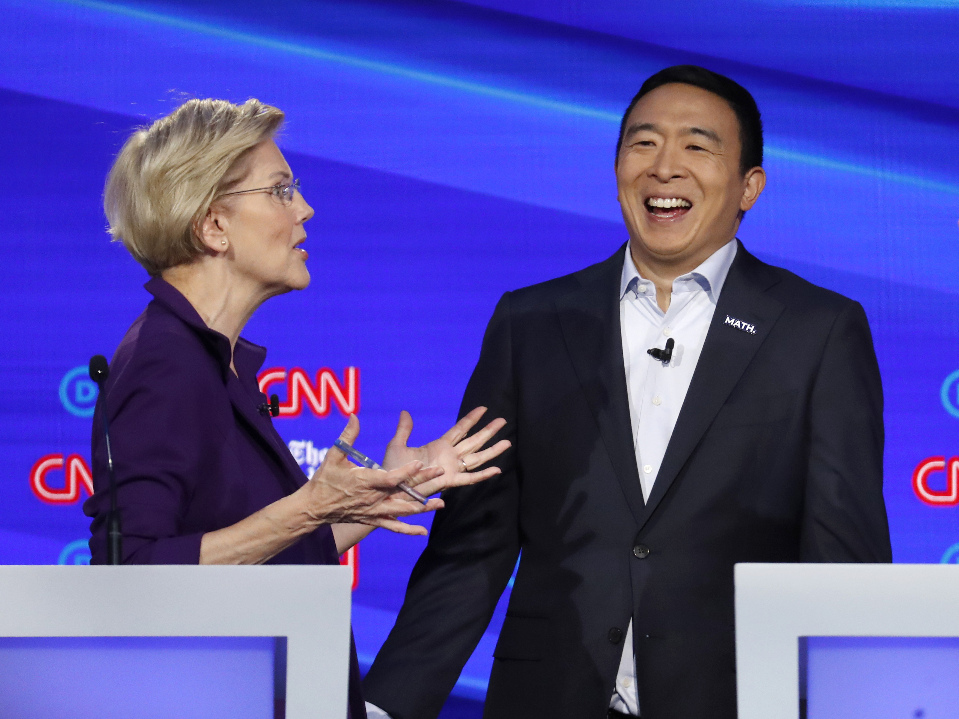 caption: Sen. Elizabeth Warren, D-Mass., and entrepreneur Andrew Yang talk during a break in the Democratic presidential primary debate hosted by CNN/<em>New York Times</em>.