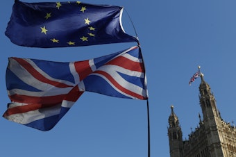caption: Flags of the European Union and Great Britain are flown during a demonstration in London on Feb. 27. A key vote is to take place in Parliament on Tuesday.