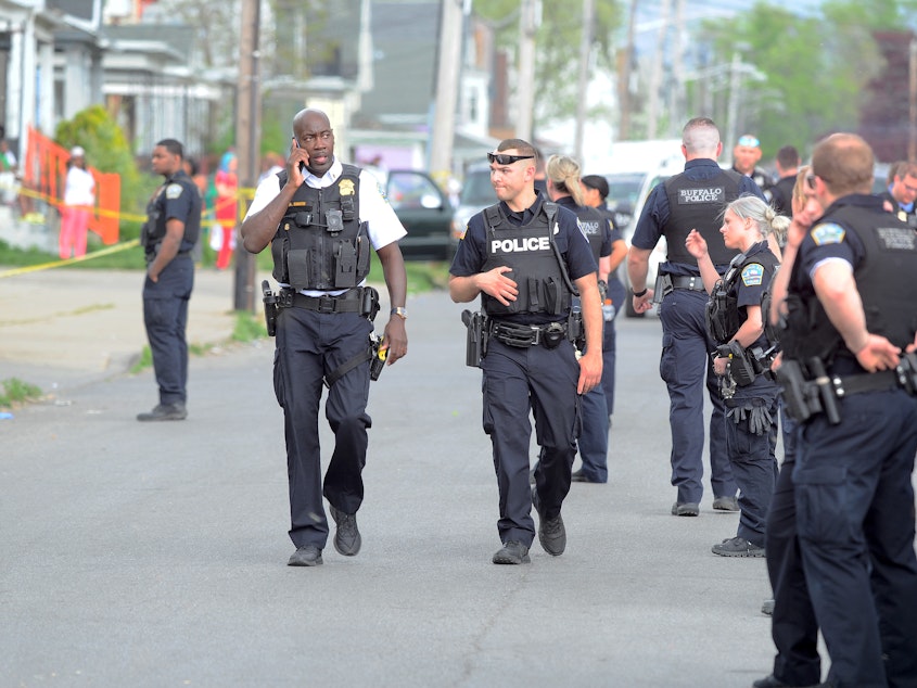 caption: Police respond to the scene of a mass shooting at a grocery store in Buffalo, N.Y. At least 10 people were killed in Saturday's violence, which authorities are investigating as a racially motivated attack.