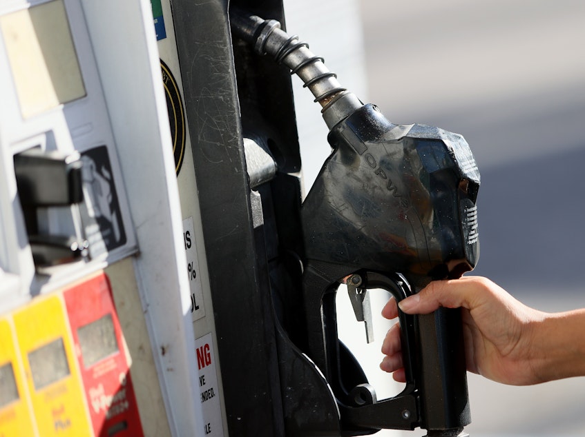 caption: Gabriela Chirinos places the handle back on the pump after filling her vehicle with gas at a Miami Shell station on Nov. 22, 2021. Florida Gov. Ron DeSantis announced he would ask state lawmakers to temporarily "zero out" state gas taxes next year.