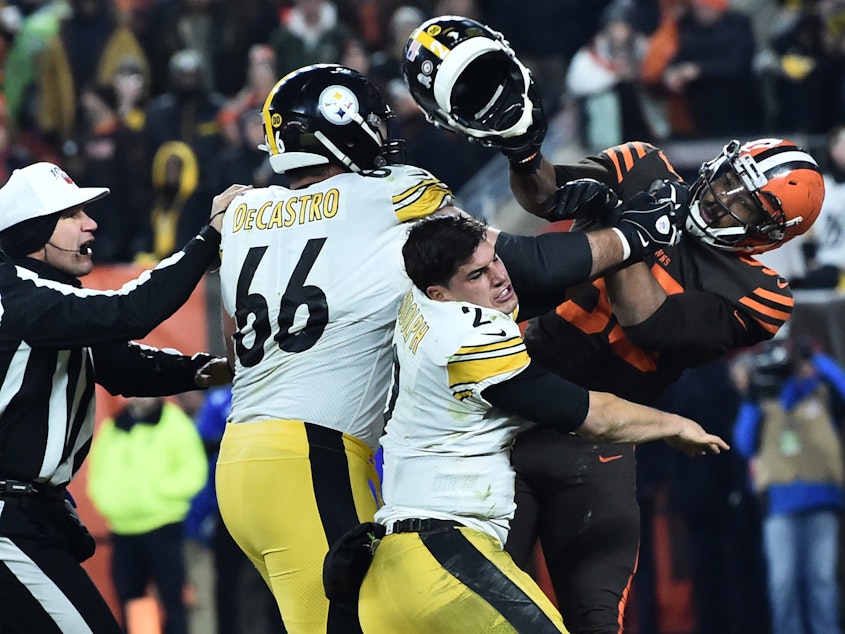 caption: Cleveland Browns defensive end Myles Garrett hits Pittsburgh Steelers quarterback Mason Rudolph with his own helmet as offensive guard David DeCastro tries to intervene, in the final seconds of their game Thursday night.
