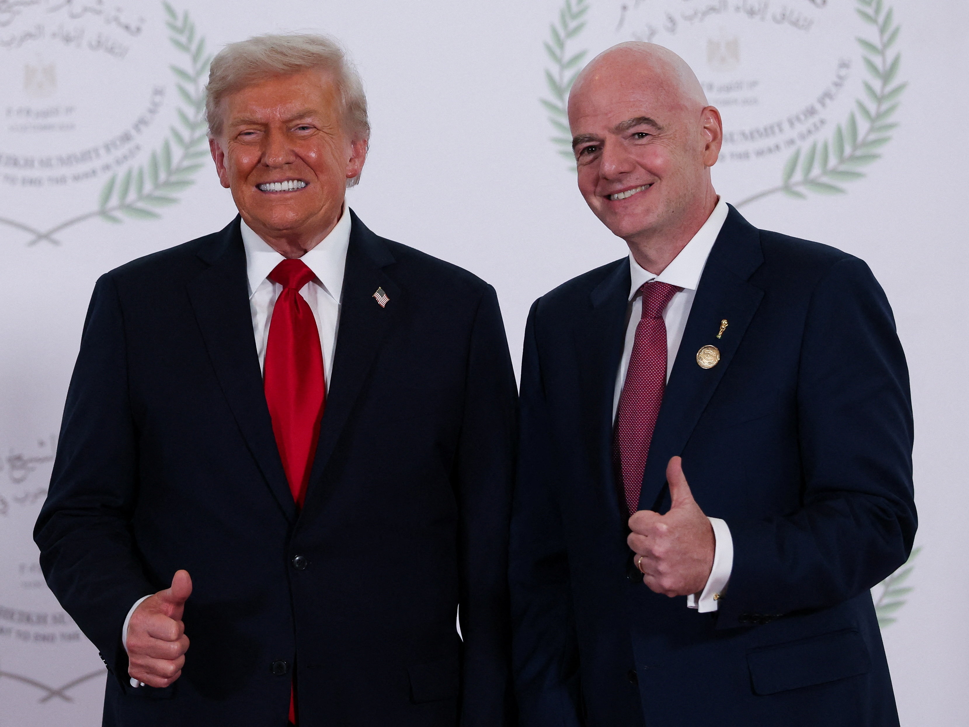 caption: President Donald Trump and FIFA president Gianni Infantino pose for a photo in Sharm el-Sheikh, Egypt, Monday, Oct. 13, 2025.