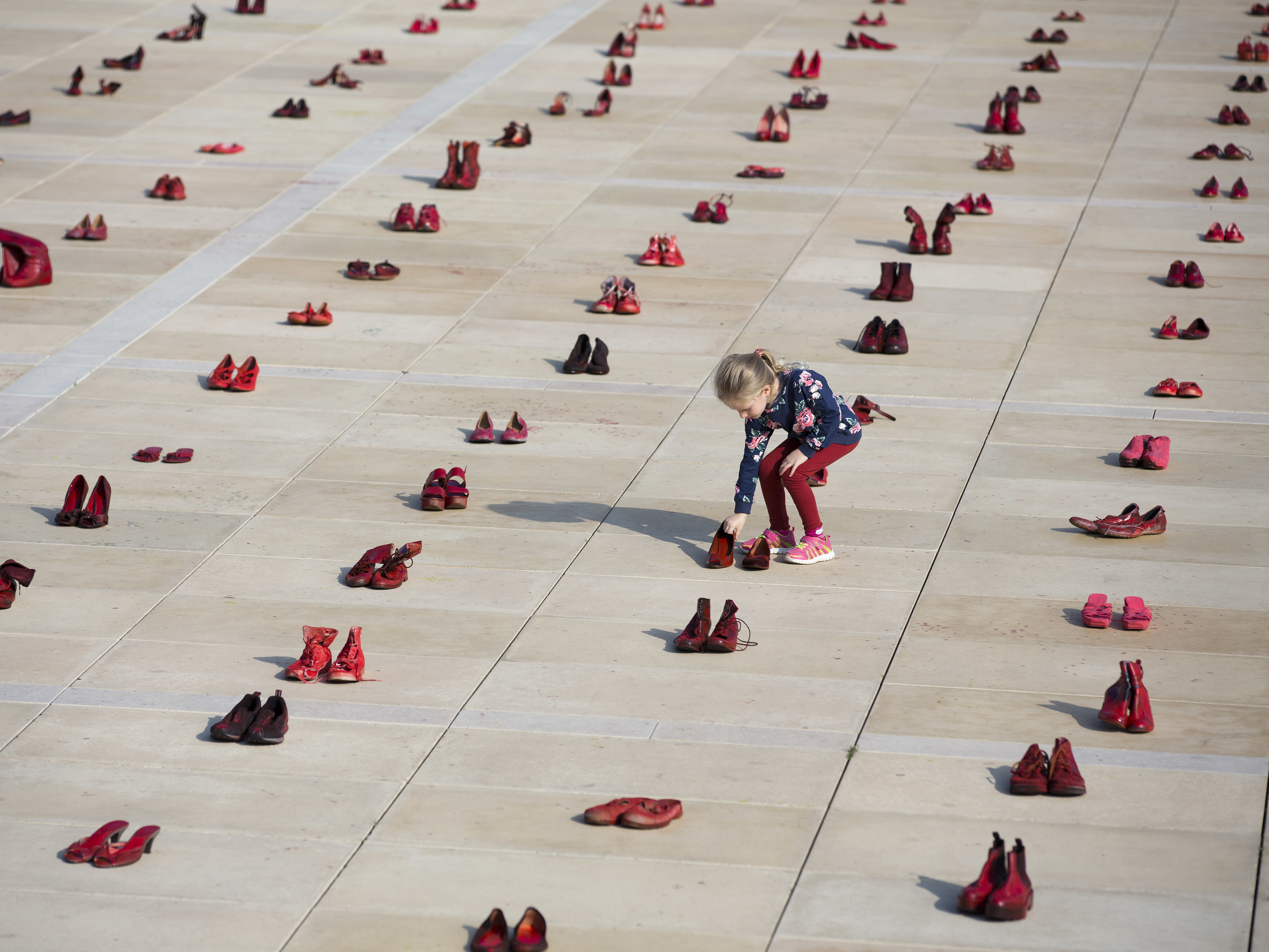 caption: Hundreds of red shoes filled Tel Aviv's Habima Square on Tuesday, part of a nationwide protest to push the government to address violence against women.