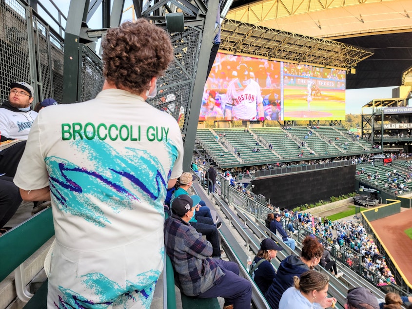 caption: Broccoli Man built a following at the ballpark with fans lining up for selfies before games. 