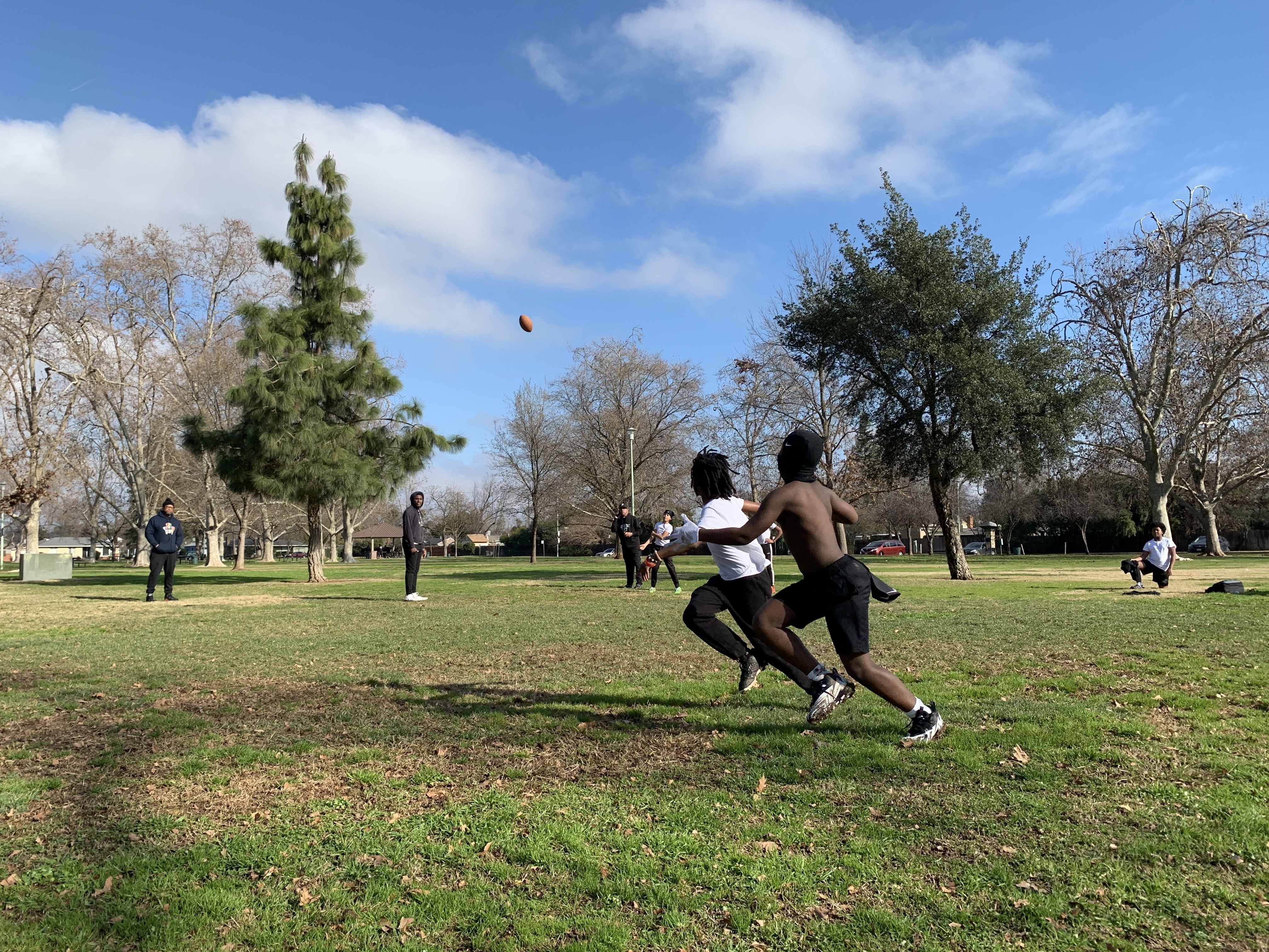 caption: Eleven-year-old Monte Johnson and 9-year-old Waylon Parker run for the ball at a 7-on-7 practice at Tahoe Park in Sacramento, California on Jan. 14, 2023
