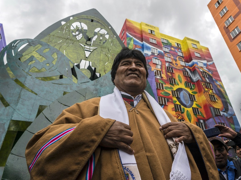 caption: President Evo Morales attended the inauguration of new buildings in a housing project in 2016. The indigenous Aymara artist Roberto Mamani Mamani painted murals over a building facade.