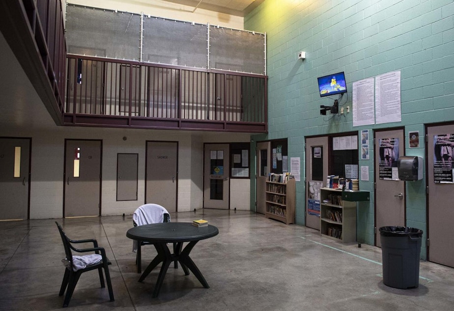 caption: A two-story common room contains doors to several detention rooms.