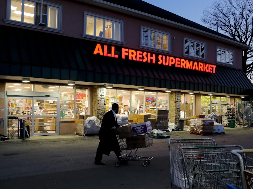 caption: An Orthodox Jewish man walks through the parking lot of a supermarket on Tuesday, in Spring Valley, N.Y. Rockland County in New York City's northern suburbs has declared a state of emergency over a measles outbreak.