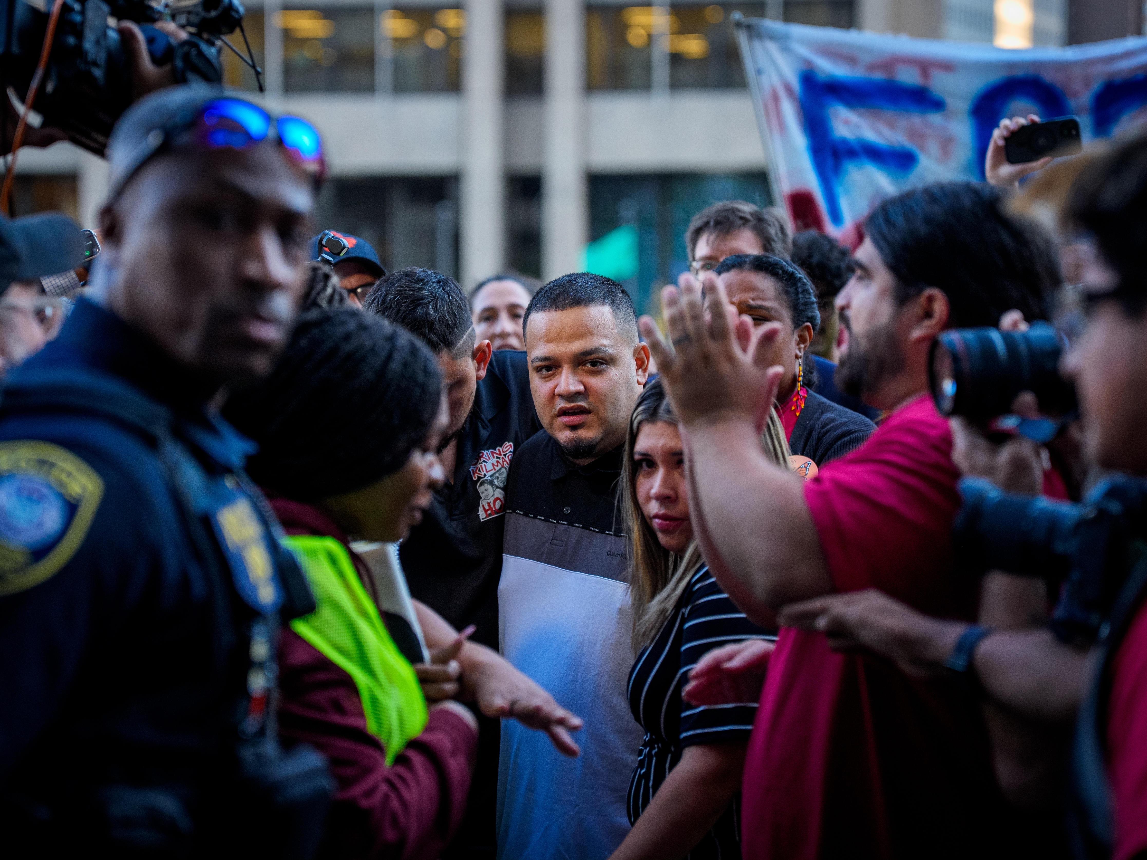 caption: Kilmar Abrego Garcia (Center) and his wife Jennifer Vasquez Sura (Center Right) enter a U.S. Immigration and Customs Enforcement (ICE) field office on Monday in Baltimore, Md. The U.S. government is threatening to deport Garcia, a Maryland construction worker from El Salvador, to Uganda after he rejected a plea deal to be charged with human smuggling and deported to Costa Rica.