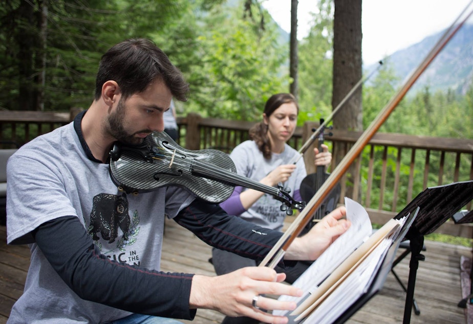 caption: Jeremy Pots and Emily Sheil perform in the North Cascades National Park.