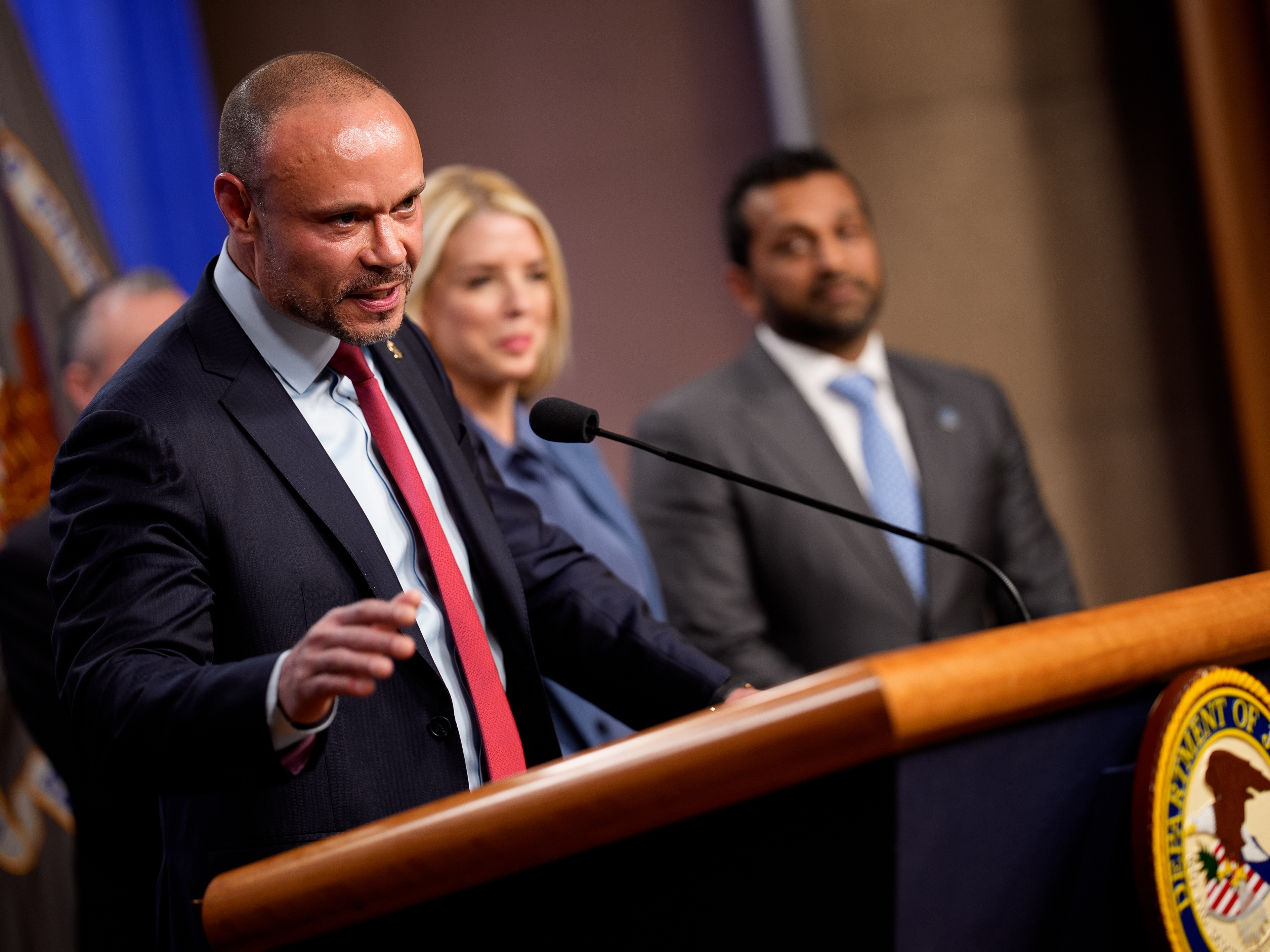 caption: FBI Deputy Director Dan Bongino speaks during a news conference on an arrest of a suspect in the January 6th pipe bomb case at the Department of Justice on Dec. 4, 2025.