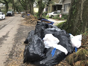 caption: Bags of garbage pile up on a New Orleans street on Friday. Trash collection delays have left some residents outraged at the city's contractors.