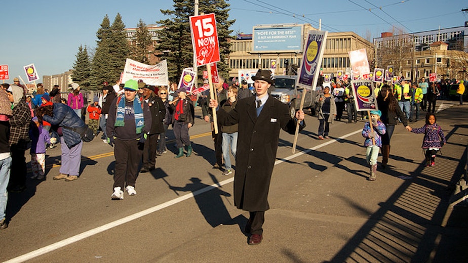 caption: Supporters for raising the minimum wage in Seattle protest in January.