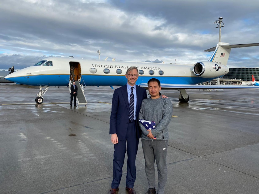 caption: This photo provided by the U.S. State Department, U.S. special representative for Iran, Brian Hook stands with Xiyue Wang in Zurich, Switzerland on Saturday.