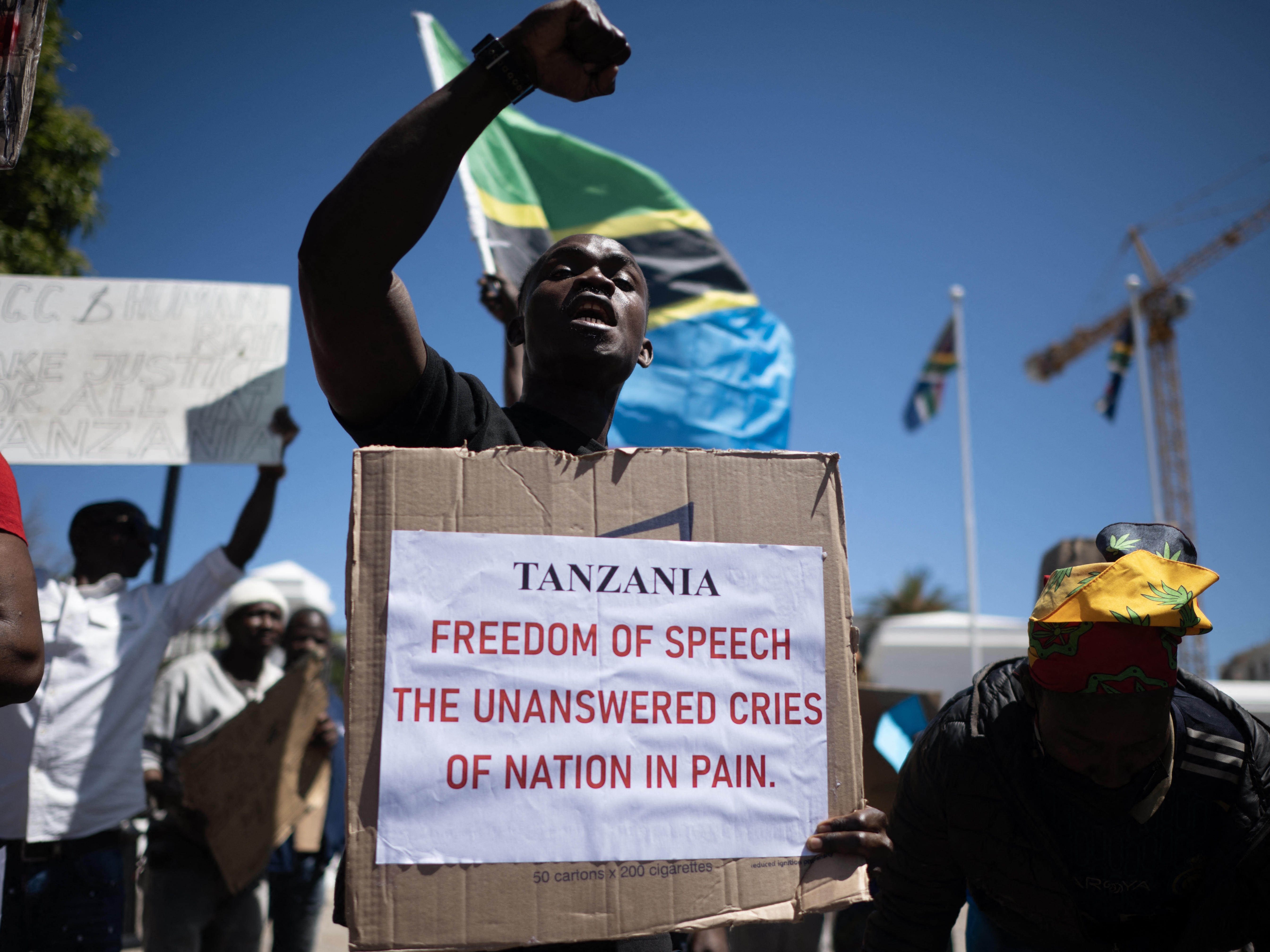 caption: A protester holds a placard during a picket in Cape Town, South Africa, protesting against the  Tanzanian government during their presidential election in Oct. 2025