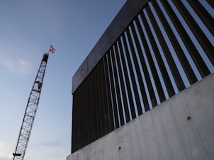 caption: A new section of the border wall is seen in November 2019 south of Donna, Texas. Trump's 576-mile border wall is expected to cost nearly $20 million per mile, which is more expensive than any other wall under construction in the world.