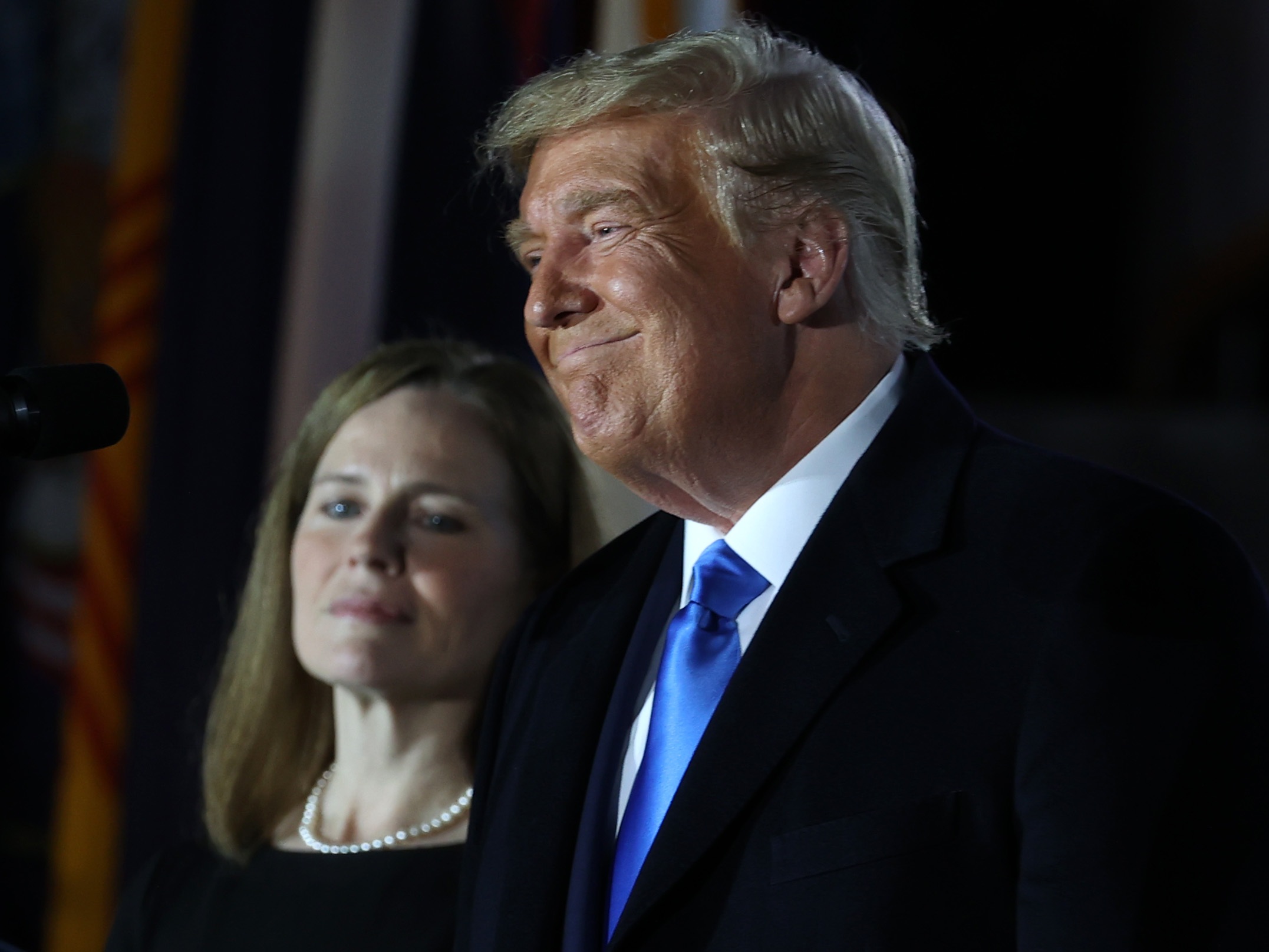 caption: Then-President Donald Trump stands next to Judge Amy Coney Barrett before her ceremonial swearing-in for the position of the U.S. Supreme Court Associate Justice in 2020.