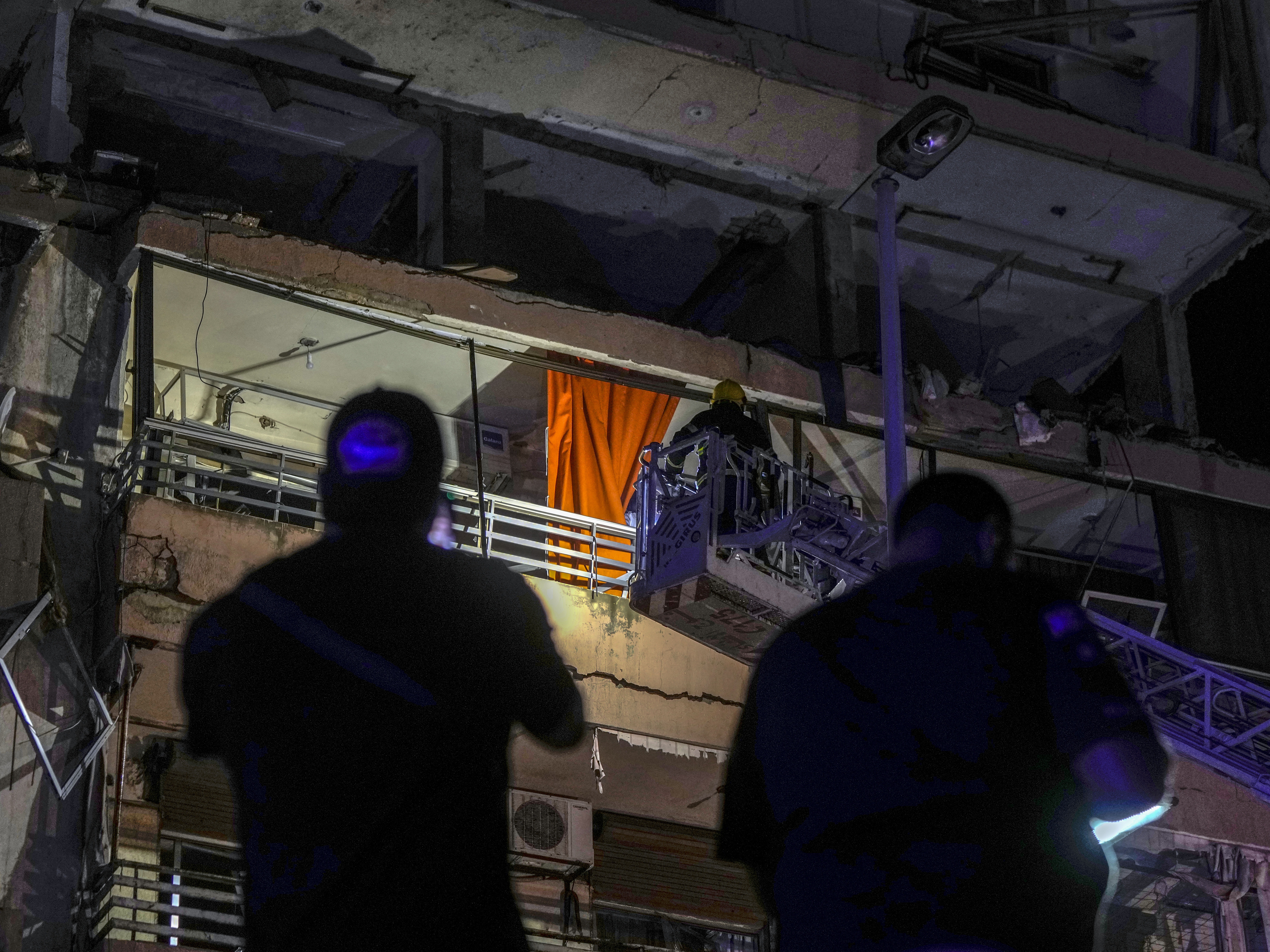 caption: A fire engine ladder extends up a building that was hit in an apparent Israeli airstrike, in central Beirut early Monday, Sept. 30, 2024.