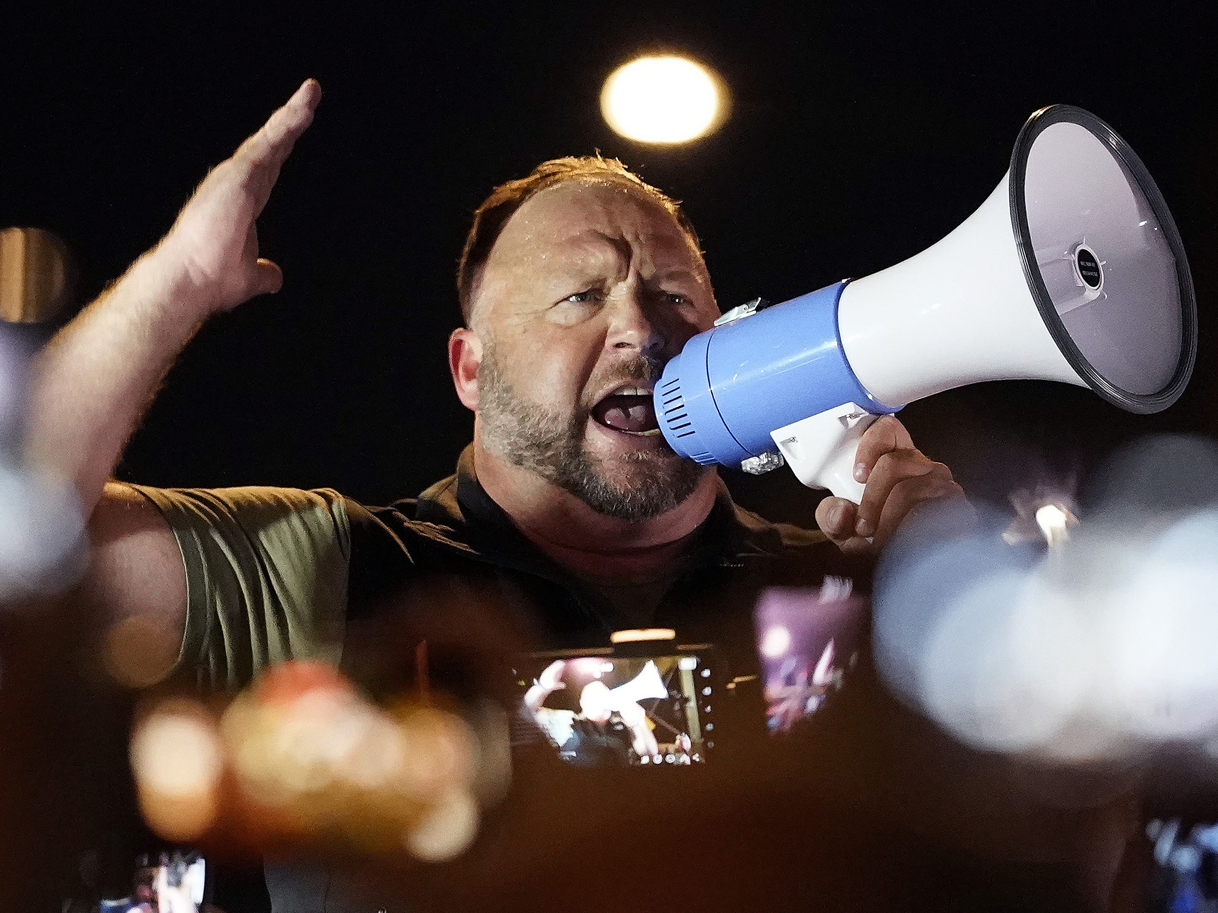 caption: Infowars host and conspiracy theorist Alex Jones rallies pro-Trump supporters outside the Maricopa County Recorder's Office, on Nov. 5, 2020, in Phoenix.