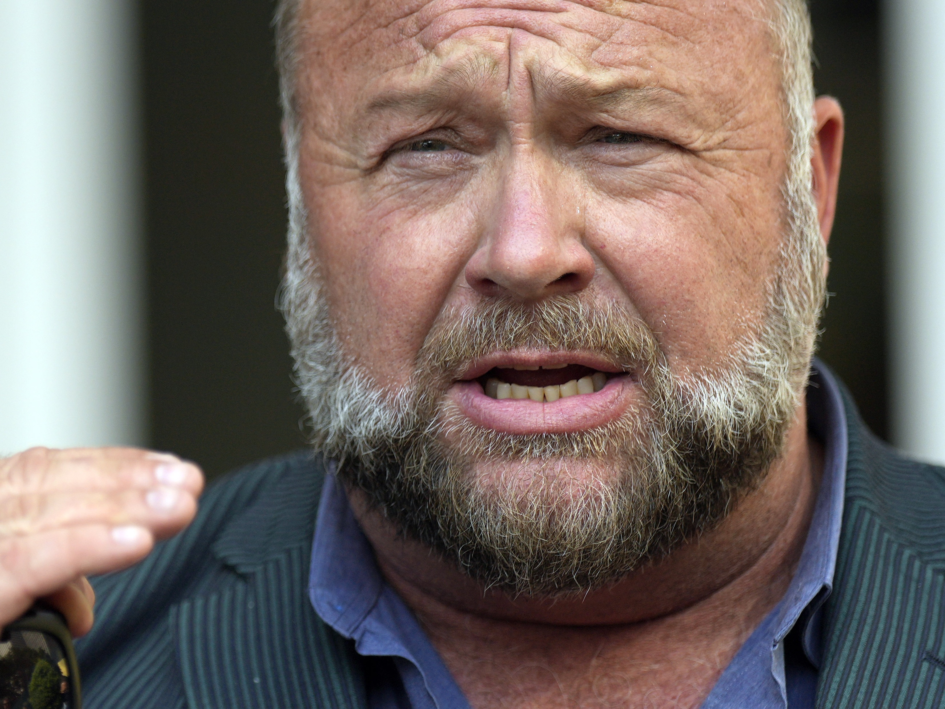 caption: Right-wing conspiracy theorist Alex Jones speaks outside the federal courthouse after a June bankruptcy hearing in Houston.