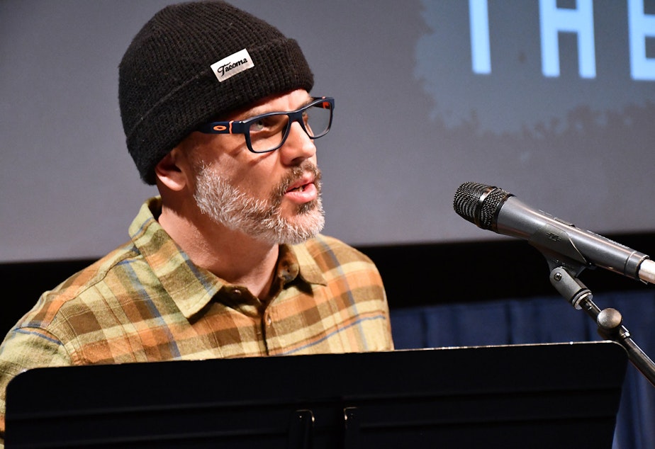 caption: Dean Burke performs his story, "The Eyes Have It," at KUOW's Stories from THE WILD event on Friday, October 11, 2019, at McCaw Hall in Seattle.