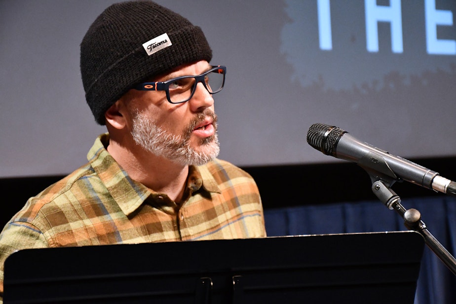 caption: Dean Burke performs his story, "The Eyes Have It," at KUOW's Stories from THE WILD event on Friday, October 11, 2019, at McCaw Hall in Seattle.
