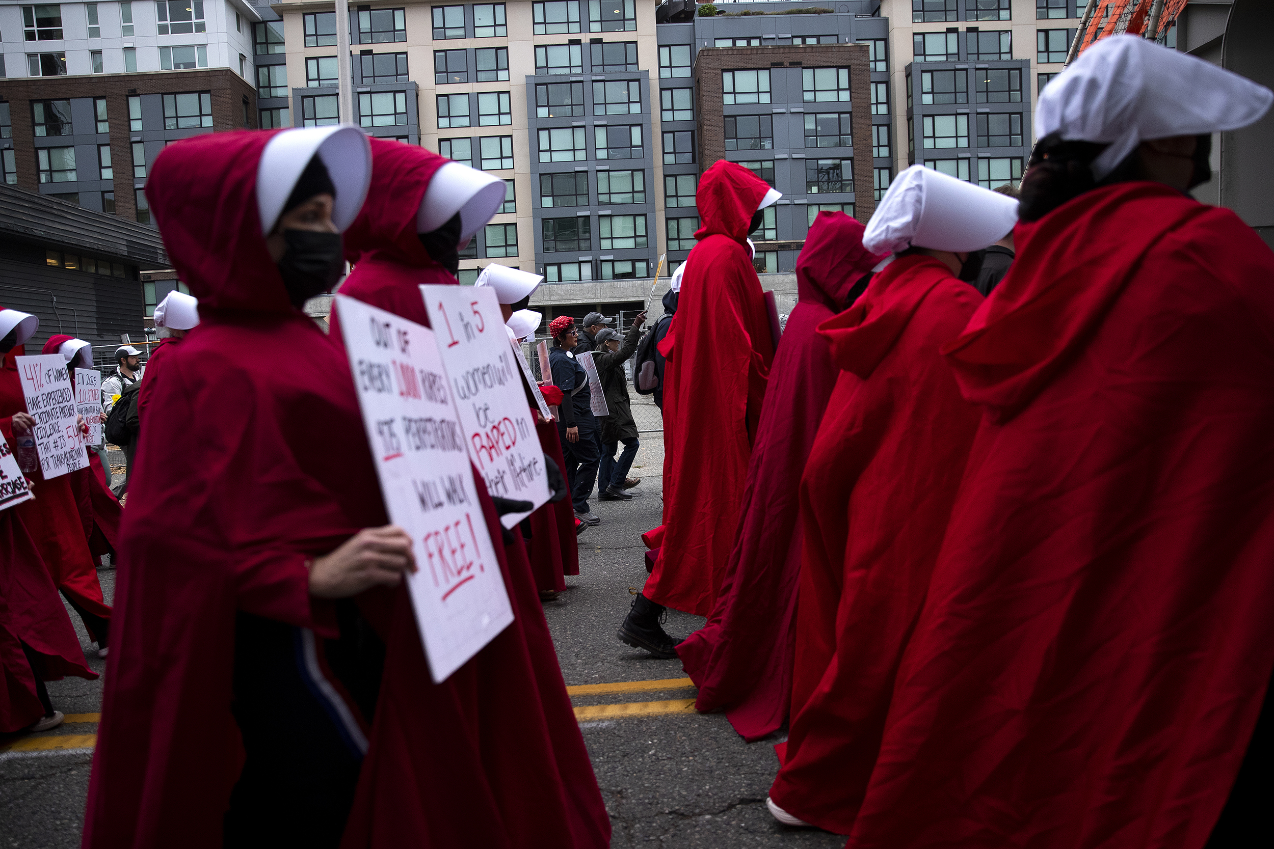 caption: Protesters dressed as Handmaids march following the No Kings rally on Saturday, October 18, 2025, in Seattle, Washington. 
