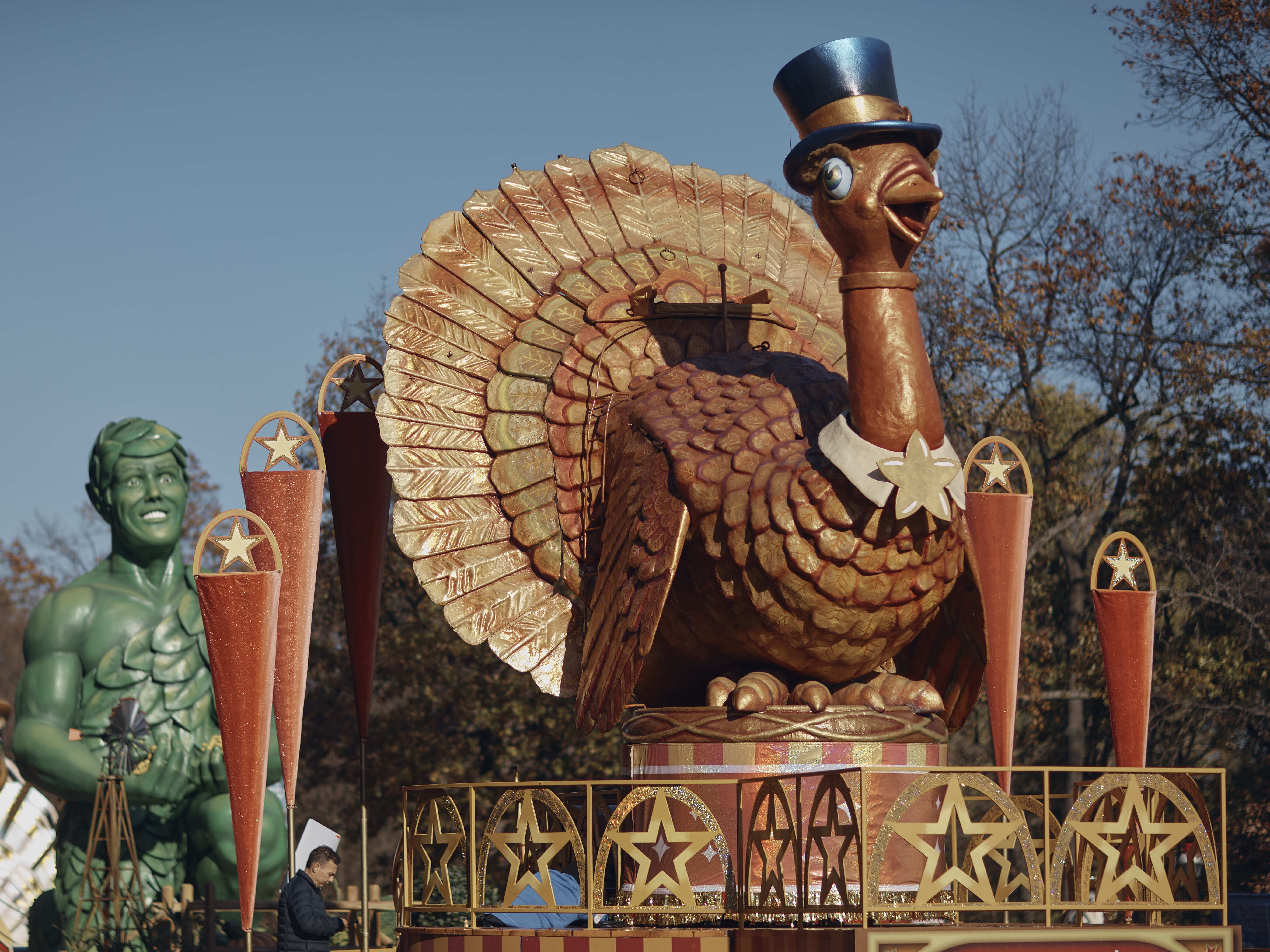 caption: A man inspects a float of Tom Turkey that is lined up for the Macy's Thanksgiving Day Parade.