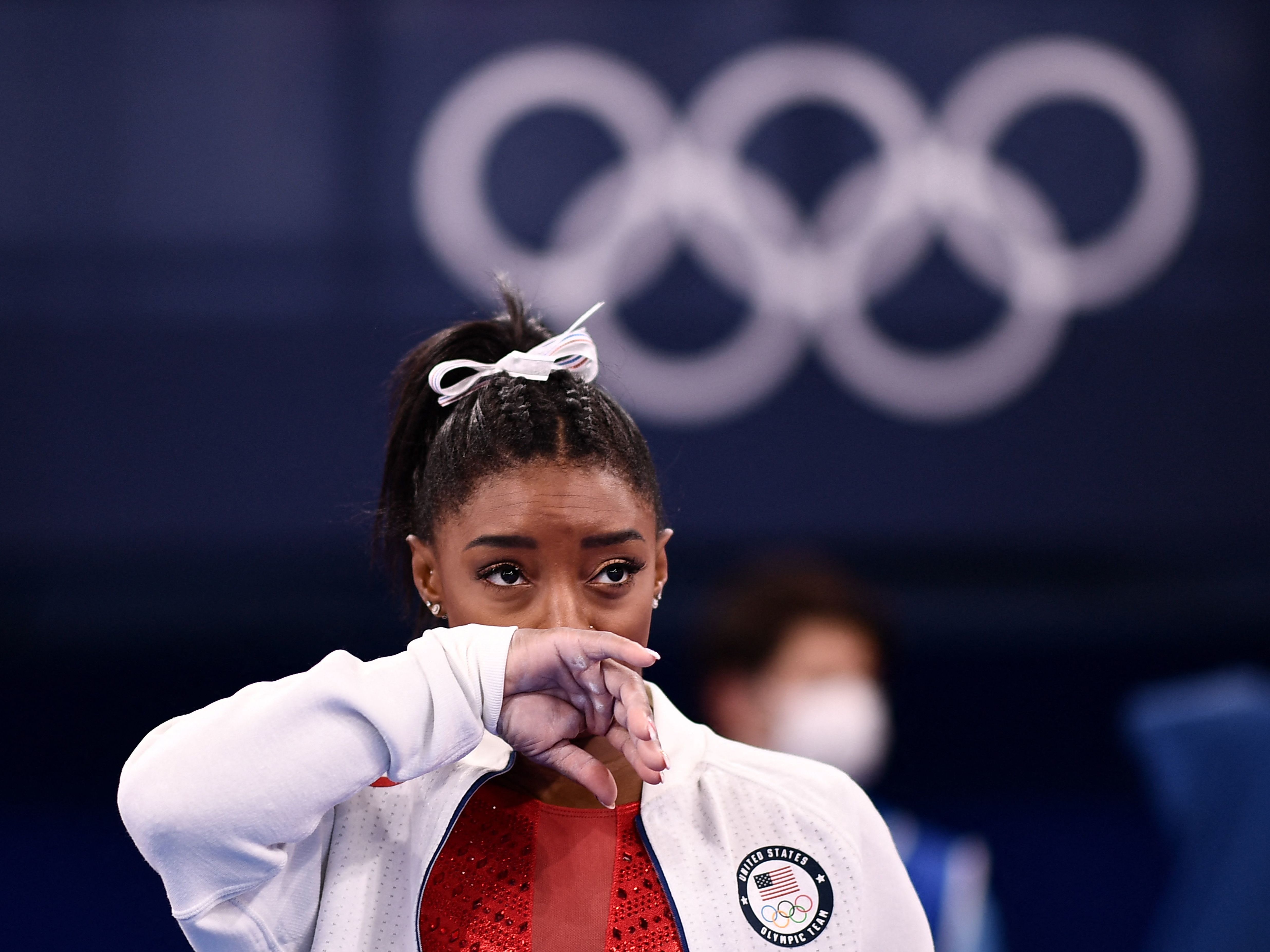 caption: Simone Biles looks on during the artistic gymnastics women's team final during the Tokyo Olympic Games on Tuesday.