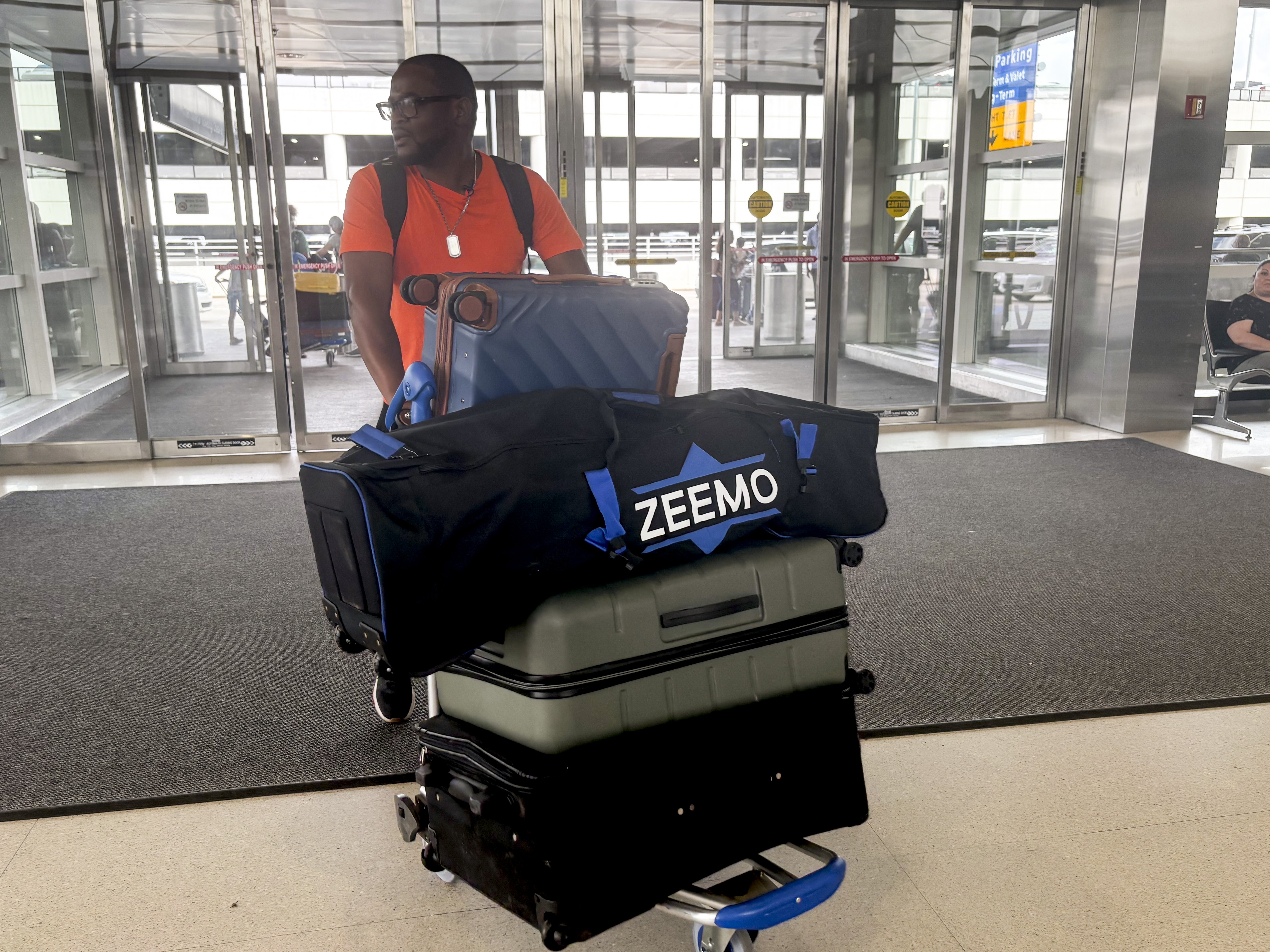 caption: Samuel Kangethe arrives with his luggage at the Detroit Metro Airport on August 17, 2025.
