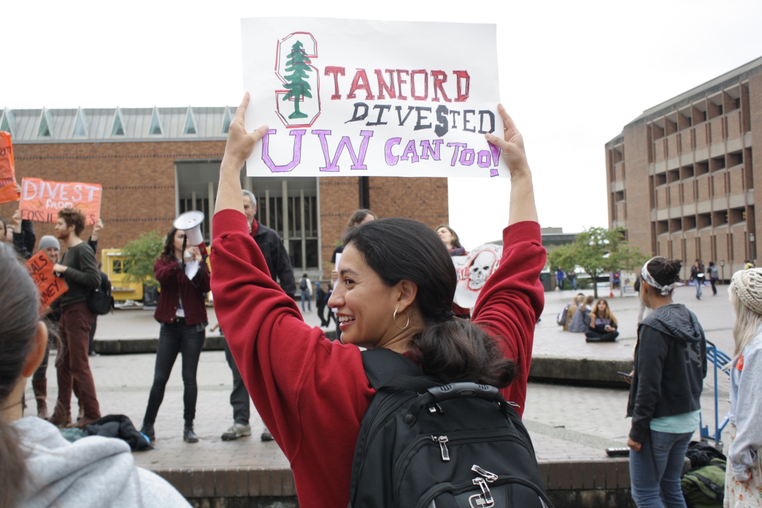 caption: Student Lorena Guillen shows her support for the UW Board of Regents, which on Thursday voted to purge the UW's endowment fund of investments in "thermal coal," a type of coal used in power plants that's associated with higher pollution levels.