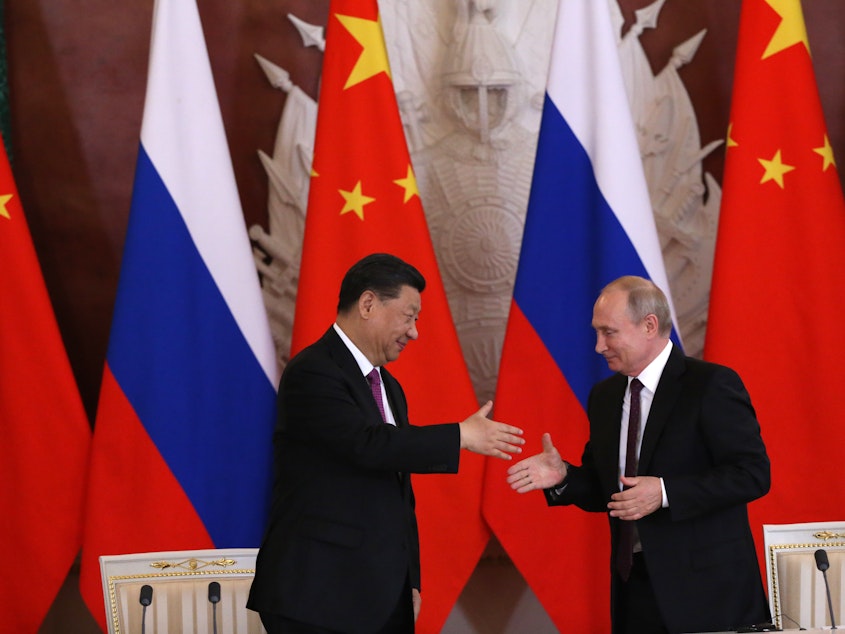 caption: Chinese President Xi Jinping and Russian President Vladimir Putin shake hands during their meeting at the Grand Kremlin Palace on Wednesday in Moscow.