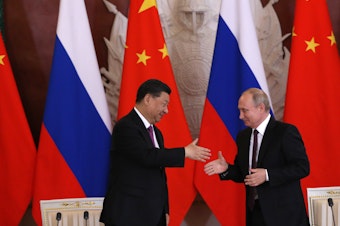 caption: Chinese President Xi Jinping and Russian President Vladimir Putin shake hands during their meeting at the Grand Kremlin Palace on Wednesday in Moscow.