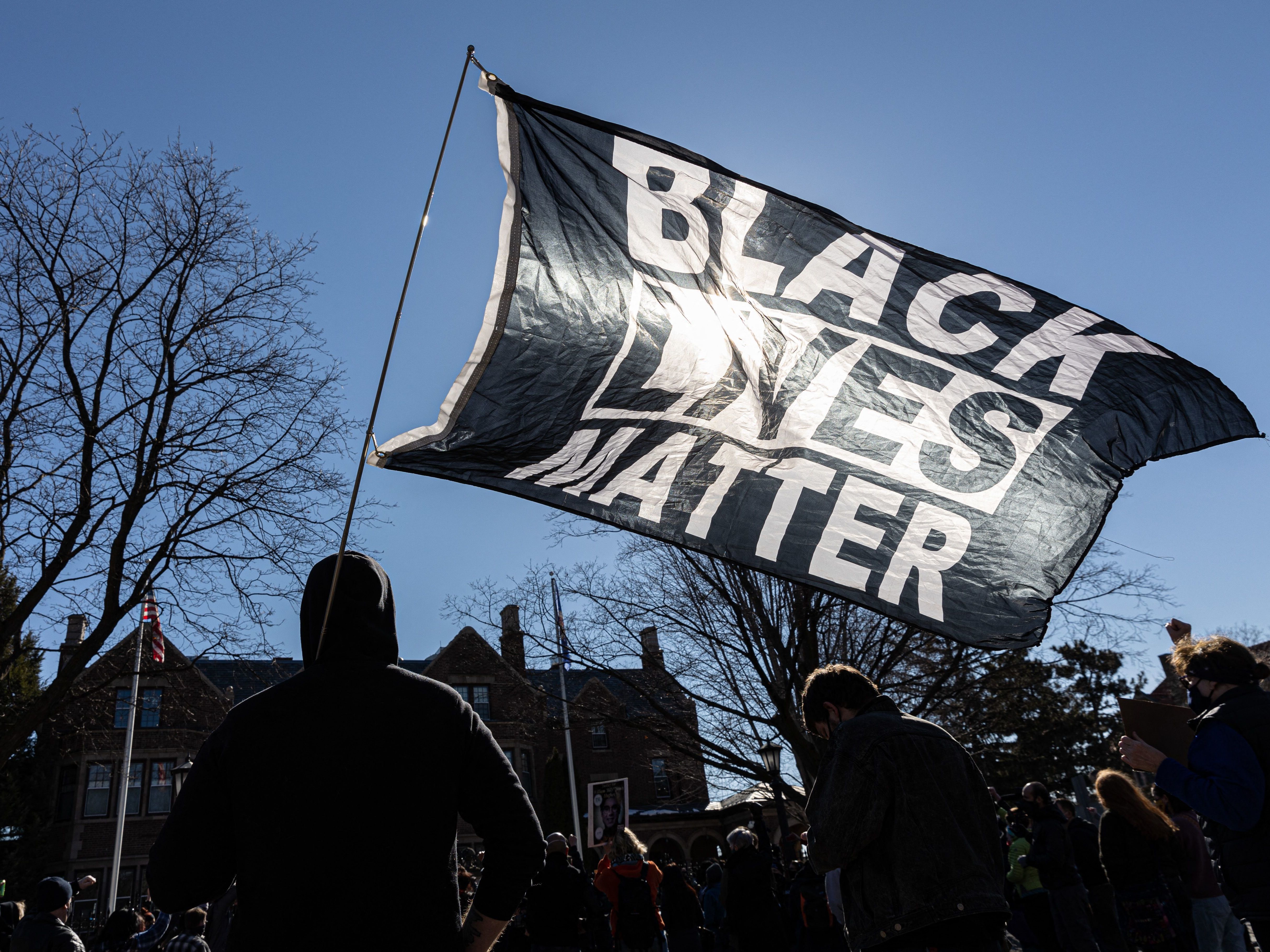 caption: A man holds a Black Lives Matter flag during a March protest in St. Paul, Minn. Support for Black Lives Matter surged after protests following George Floyd's death. Activists charge that disparaging posts targeting BLM are part of an overall effort to undermine the movement and its message.