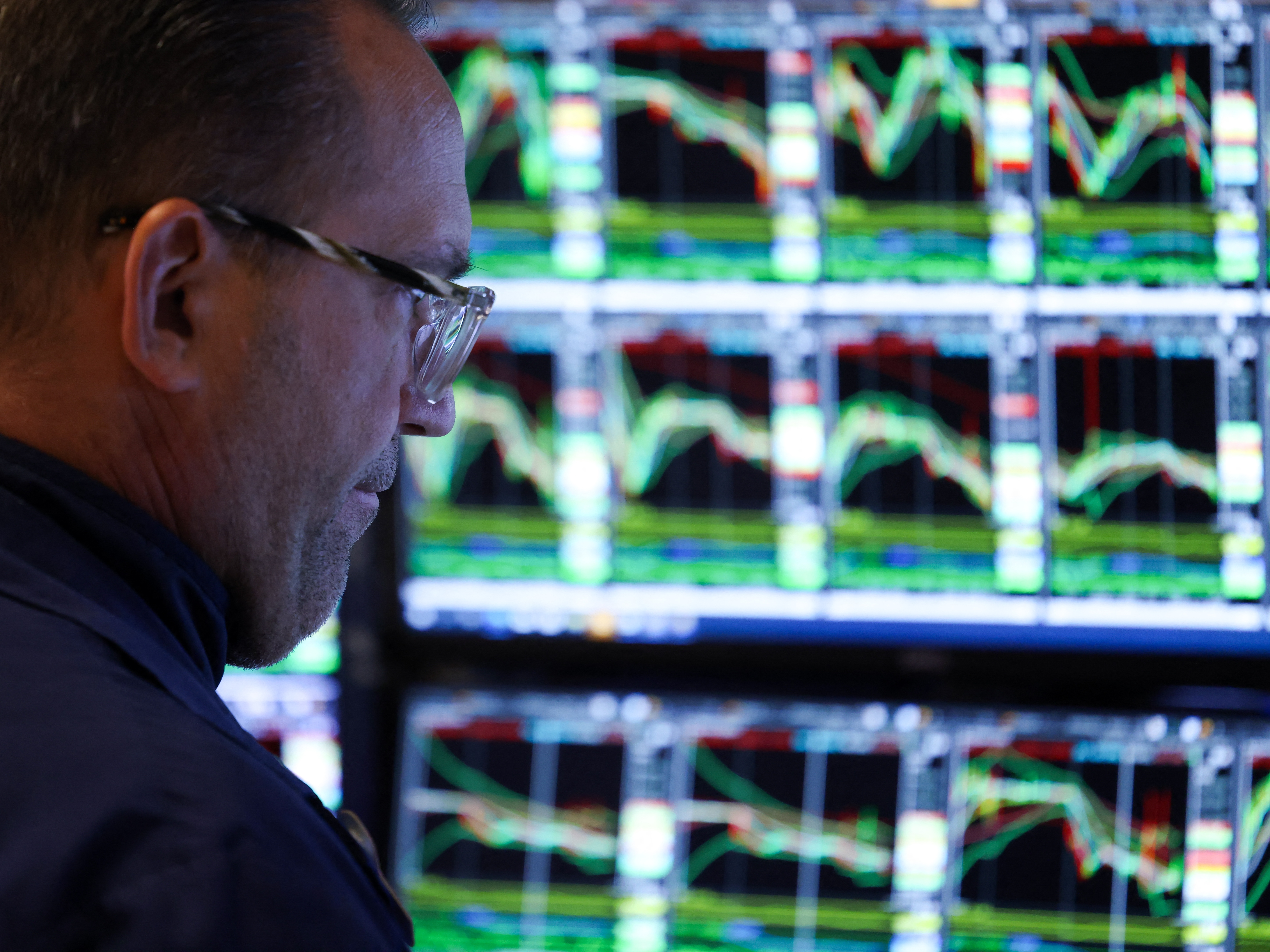 caption: A trader works on the floor of the New York Stock Exchange (NYSE) at the opening bell in New York City on March 10, 2025.