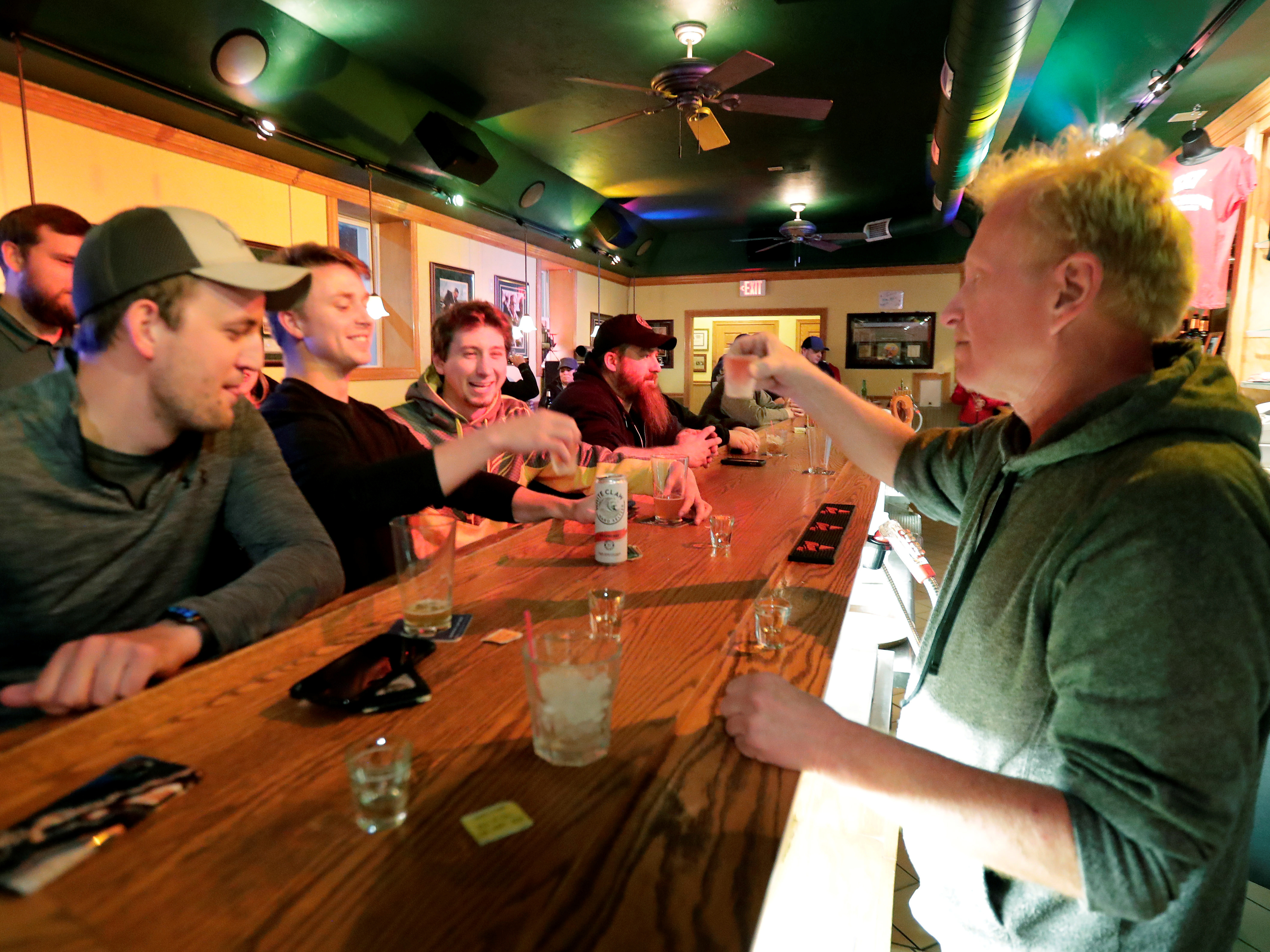 caption: Bar owner Michael Mattson toasts with patrons as his Friends and Neighbors bar reopens Wednesday in Appleton, Wis. Bars were able to open their doors after the Wisconsin Supreme Court struck down the state's "Safer at Home" order.