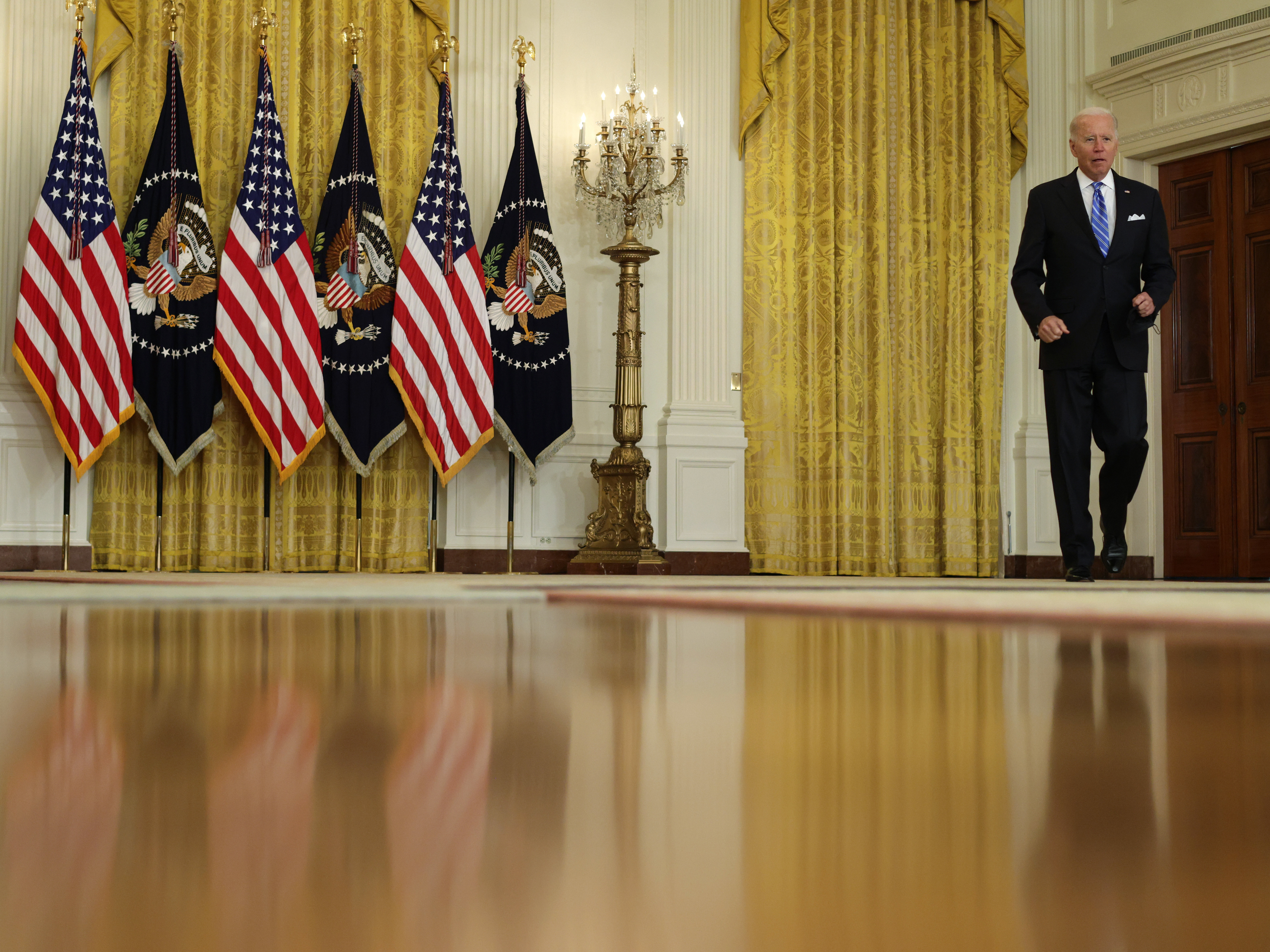 caption: President Biden is returning to the White House on Monday afternoon from Camp David. Here he arrives last week at an East Room event.