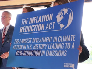 caption: A sign touting the Inflation Reduction Act is seen at Glynwood Boat House in Cold Spring, N.Y., on Aug. 17, 2022.