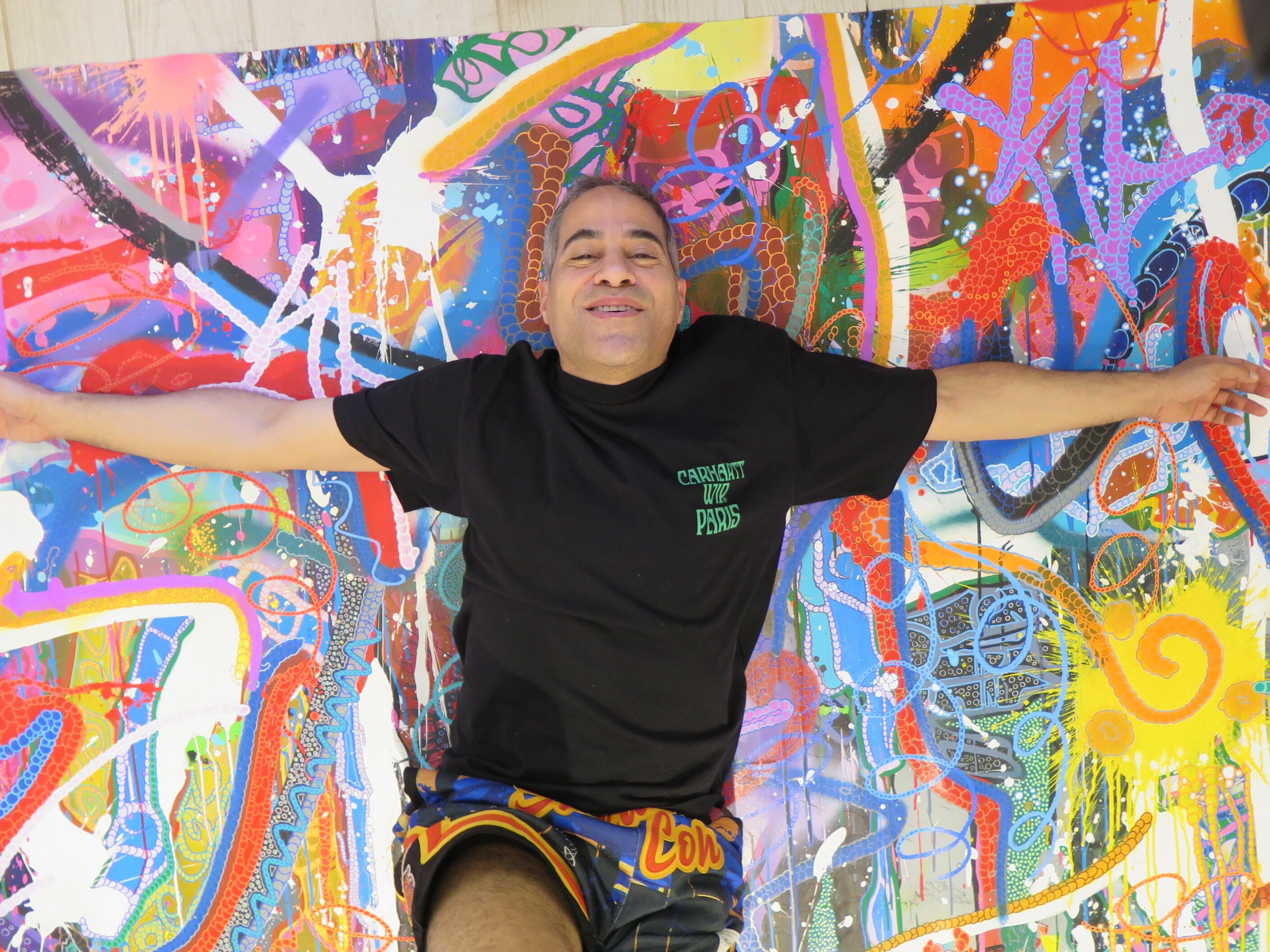 caption: JonOne with one of the paintings featured in his solo show at Miami's Museum of Graffiti.