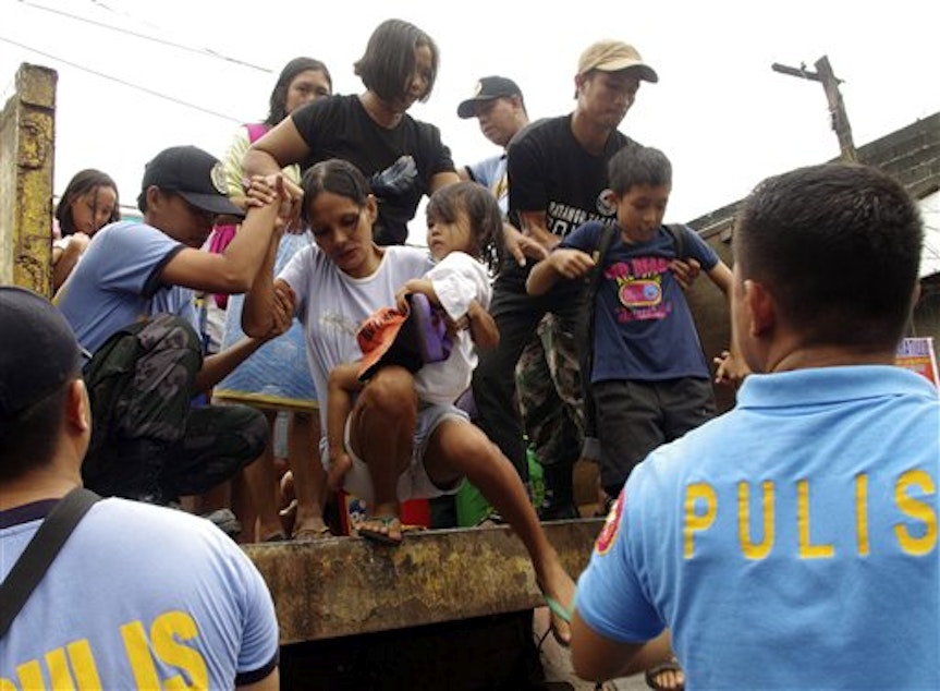 caption: Residents living near the slopes of Mayon volcano are evacuated, Nov. 7, 2013,to public schools by police in anticipation of the powerful Typhoon Haiyan in central Philippines. 