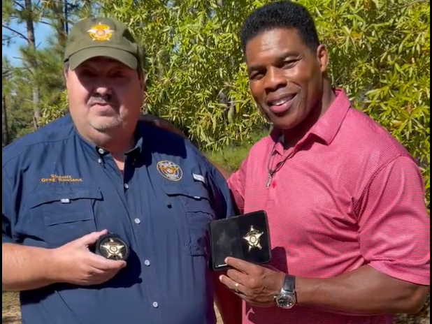 caption: Johnson County Sheriff Greg Rowland (left) stands in support of former football star-turned-prospective-politician Herschel Walker. Rowland said if Walker's badge is a prop, then so is his, which he carries every day in the line of duty. Following a heated debate last Friday, Walker ordered 1,000 imitation badges to be used as props for an upcoming fundraising event.