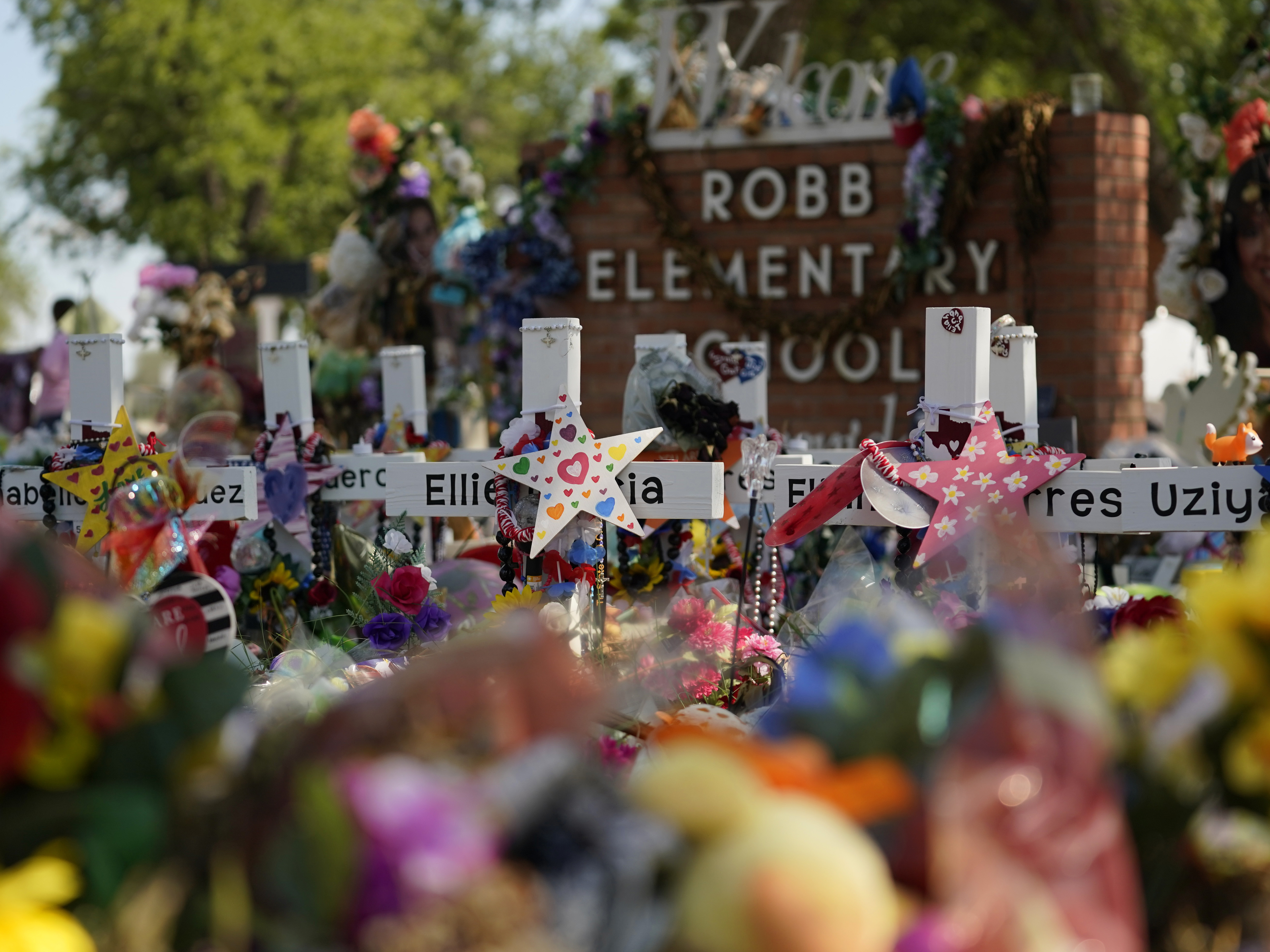 caption: Crosses, flowers and other memorabilia form a make-shift memorial for the victims of the shootings at Robb Elementary School in Uvalde, Texas.