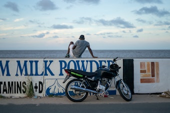 caption: A seawall stretches for hundreds of miles along the coast of Guyana, in northern South America. It protects the low-lying coastal lands where the majority of Guyana's population lives. The region is acutely threatened by rising sea levels, as well as other symptoms of climate change, yet Guyana is embracing the oil industry.