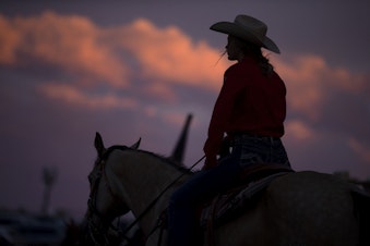 caption: A scene from the Freedom Rodeo in Basin City, Wash. on Friday, June 17, 2022. This photo was part of the coverage from the podcast "Ghost Herd," about a major cattle crime in Washington. KUOW won an Edward R. Murrow award for the podcast in 2024.