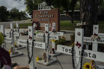 caption: The memorial at Robb Elementary School in Uvalde, Texas. A mass shooting there on May 24, 2022, killed 19 children and two teachers. For surviving families, the year since has been an agonizing fight for answers and accountability.
